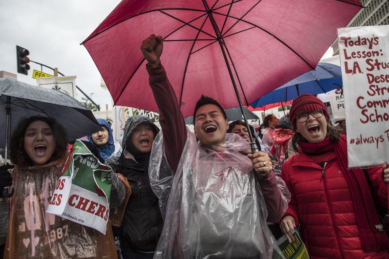 One demonstrator, holding his fist up in the air and holding an umbrella with his other arm, appears to chant loudly. Those in the crowd around him appear equally enthusiastic.